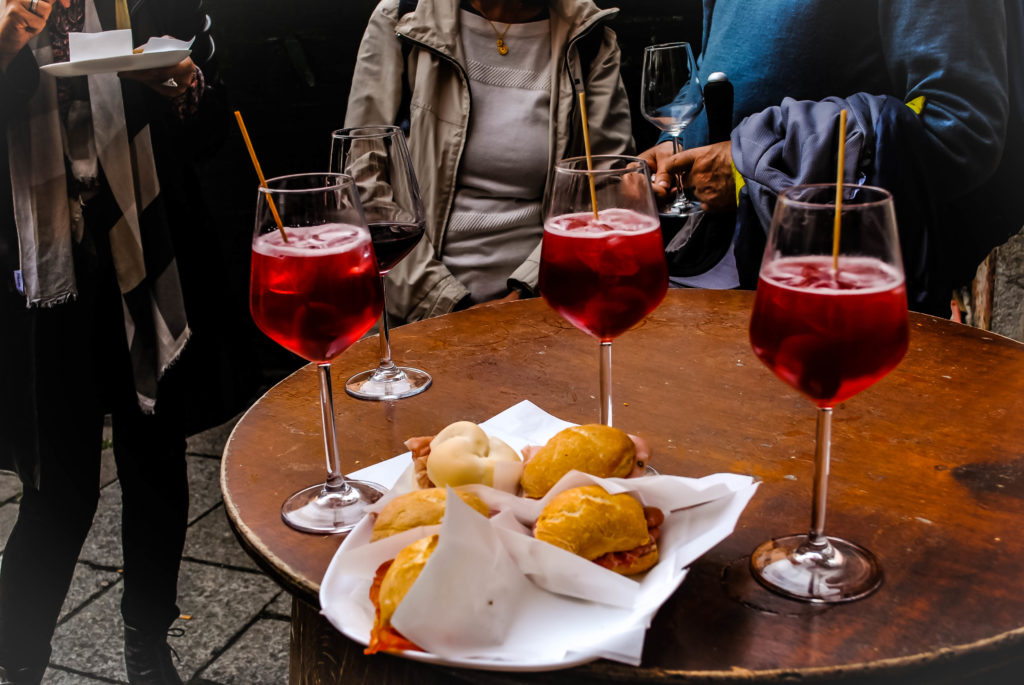 Sharing a small table with some locals, drinking Venetian Spritzes and eating small sandwiches full of heavenly meats.
